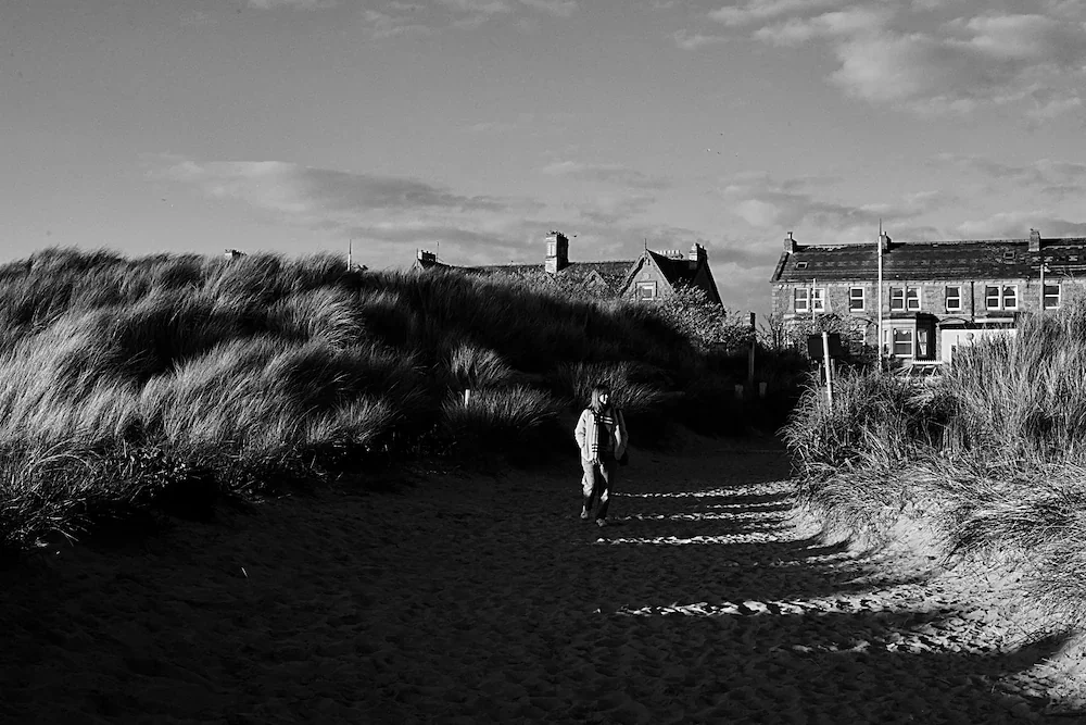 northwest-coast-person-dunes-coastal-houses-bw.webp