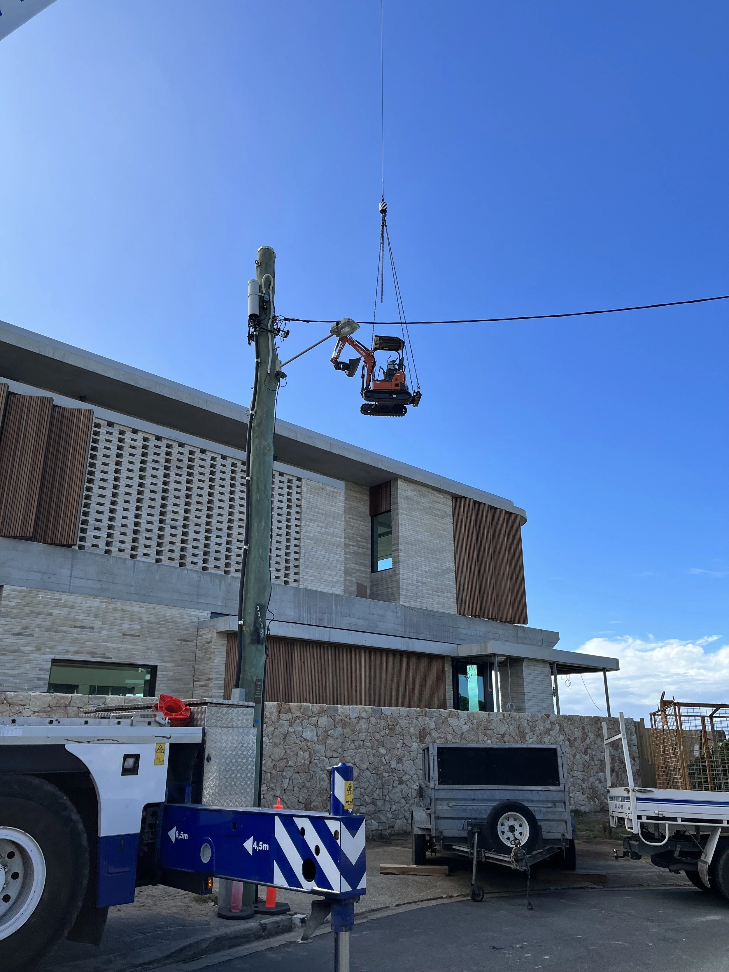 MC Diggers: Small digger being craned in on-site, Mermaid Beach, Gold Coast