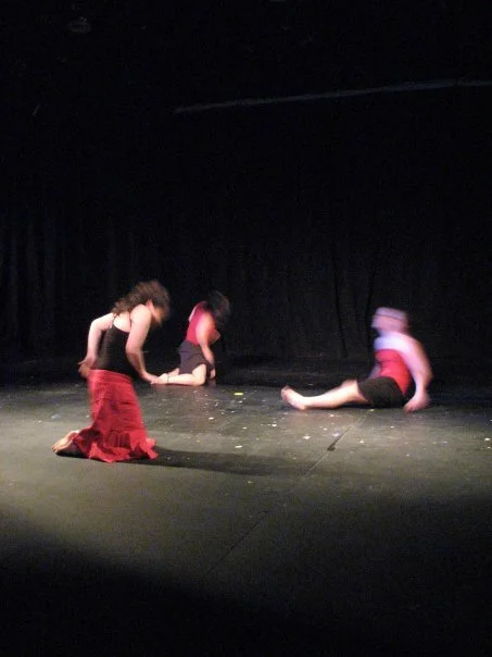 Three dancers performing on a stage