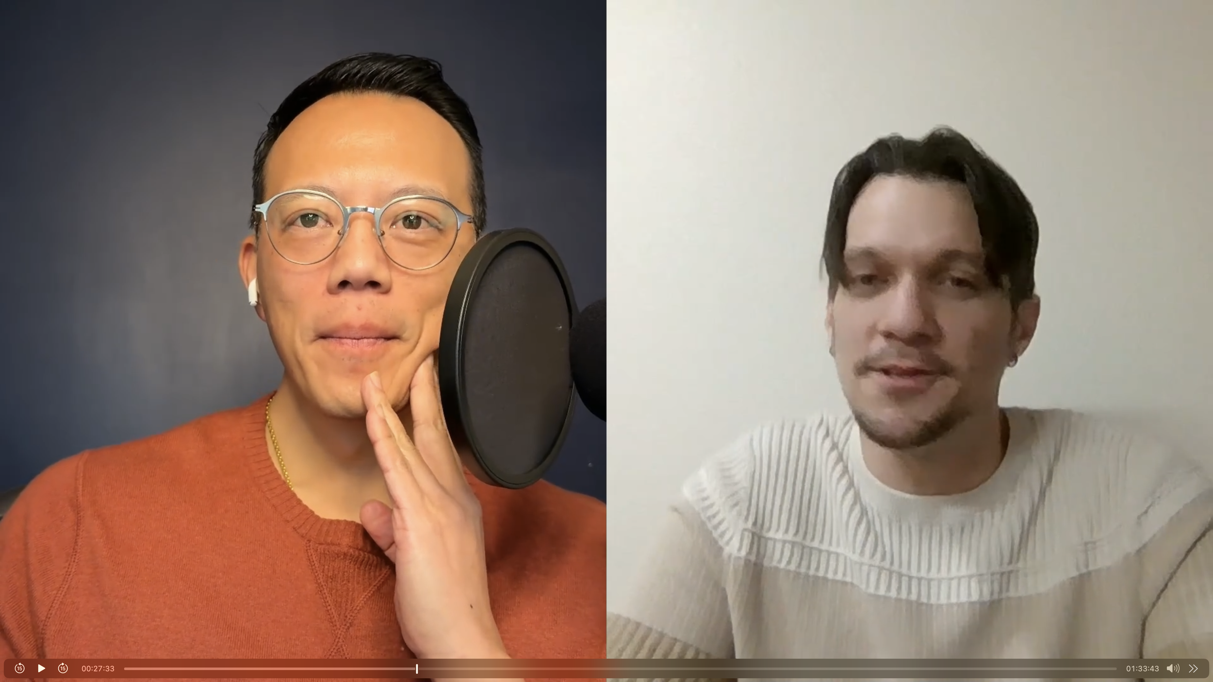 Two men are engaged in a video call, one with glasses and short dark hair, wearing an orange sweater and white Airpods, speaking into a microphone, with a dark background; the other with medium-length dark hair, wearing a white ribbed shirt, sitting against a plain white wall.