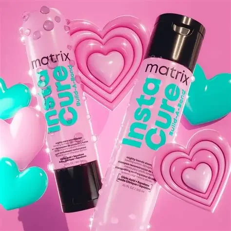 Two bottles of Matrix Insta Cure liquid glue surrounded by pink and blue heart-shaped decorations with a pink background.