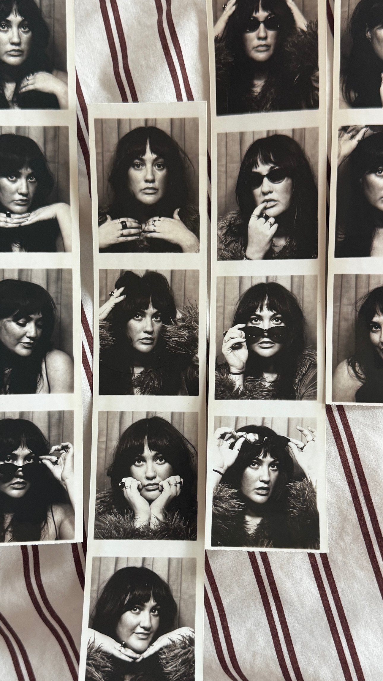 Black and white photo booth strips featuring a woman with dark hair, bangs, and various sunglasses and poses.
