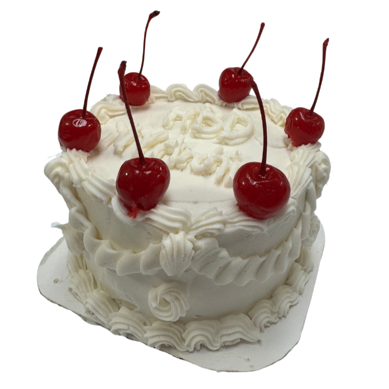 A round white cake decorated with white icing, topped with five maraschino cherries, and adorned with piped white icing decorations.