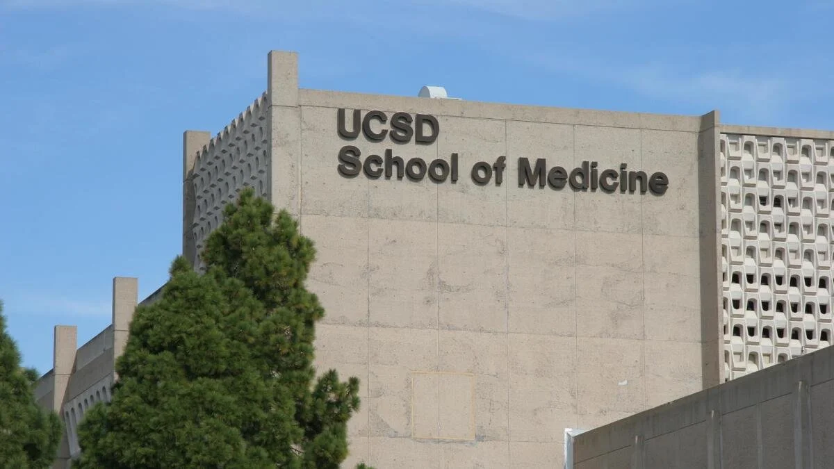 Exterior of UCSD School of Medicine building with a large tree in the foreground and a blue sky in the background. Luis Santaella UCSD was an honorary faculty member at the UCSD School of Medicine.