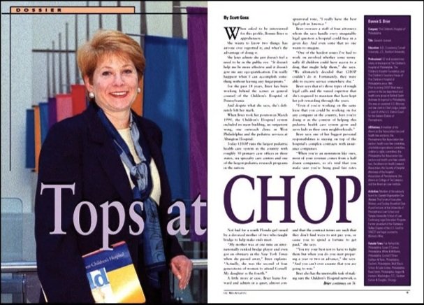 tear sheet magazine article of a female professional hospital legal administrator at Children's Hospital with short blonde hair smiling, wearing a dark blazer, with a bag and blue scarf, standing in front of a blue and gray background.
