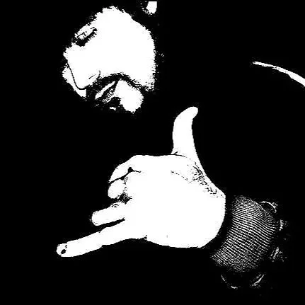 Person with a beard showing a thumbs-up and holding up a hand with fingers making an 'L' shape.