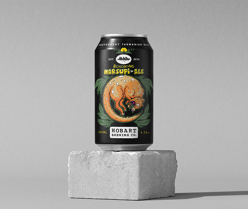 A black can of Bonorong Marsupi Ale beer by Hobart Brewing Co. with a colorful marsupial illustration, placed on a gray stone block against a gray background.