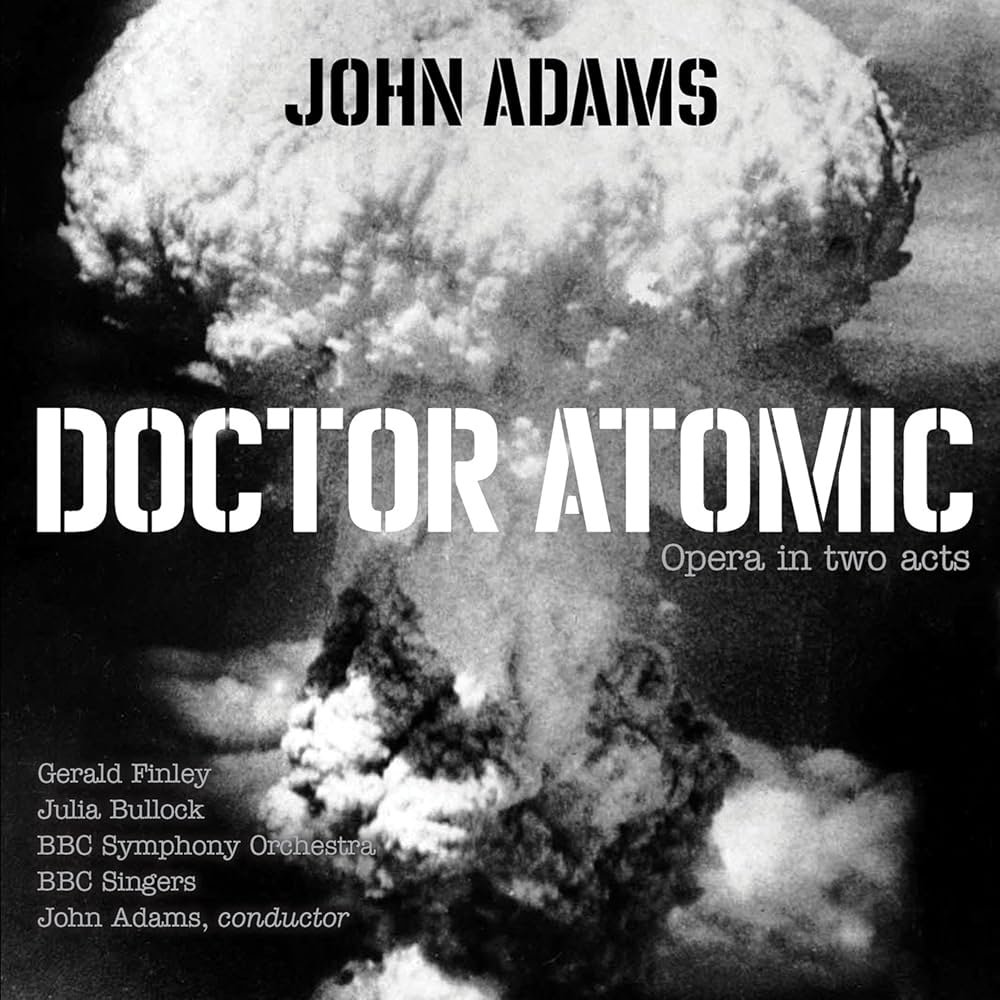 Black and white poster featuring an explosion with large mushroom cloud, promoting 'Doctor Atomic,' an opera by John Adams, with performers Gerald Finley, Julia Bullock, BBC Symphony Orchestra and BBC Singers, conducted by John Adams.
