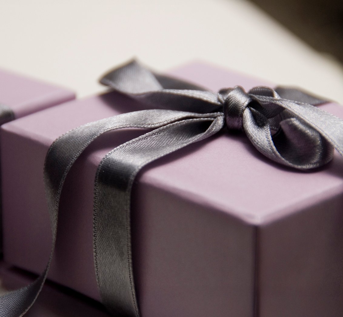 A gift box wrapped with a satin ribbon tied in a bow.