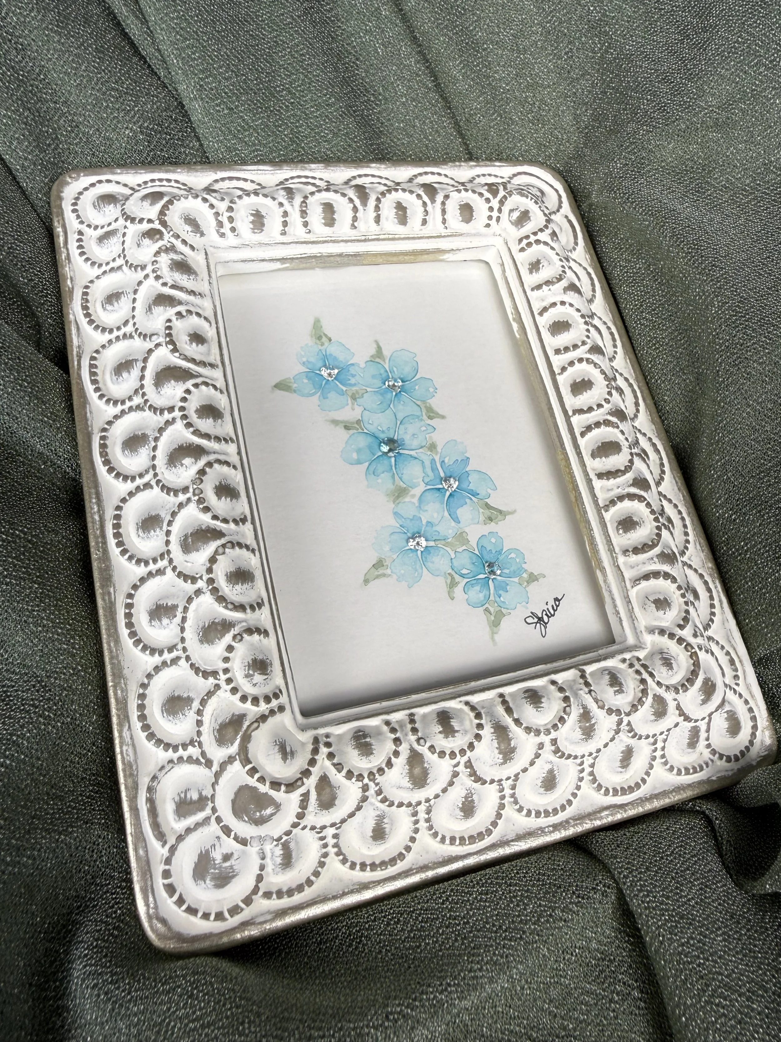 Aqua Falls watercolor painting of cascading teal flowers with apatite and white topaz gemstones in an ornate white frame by Stacia Shane