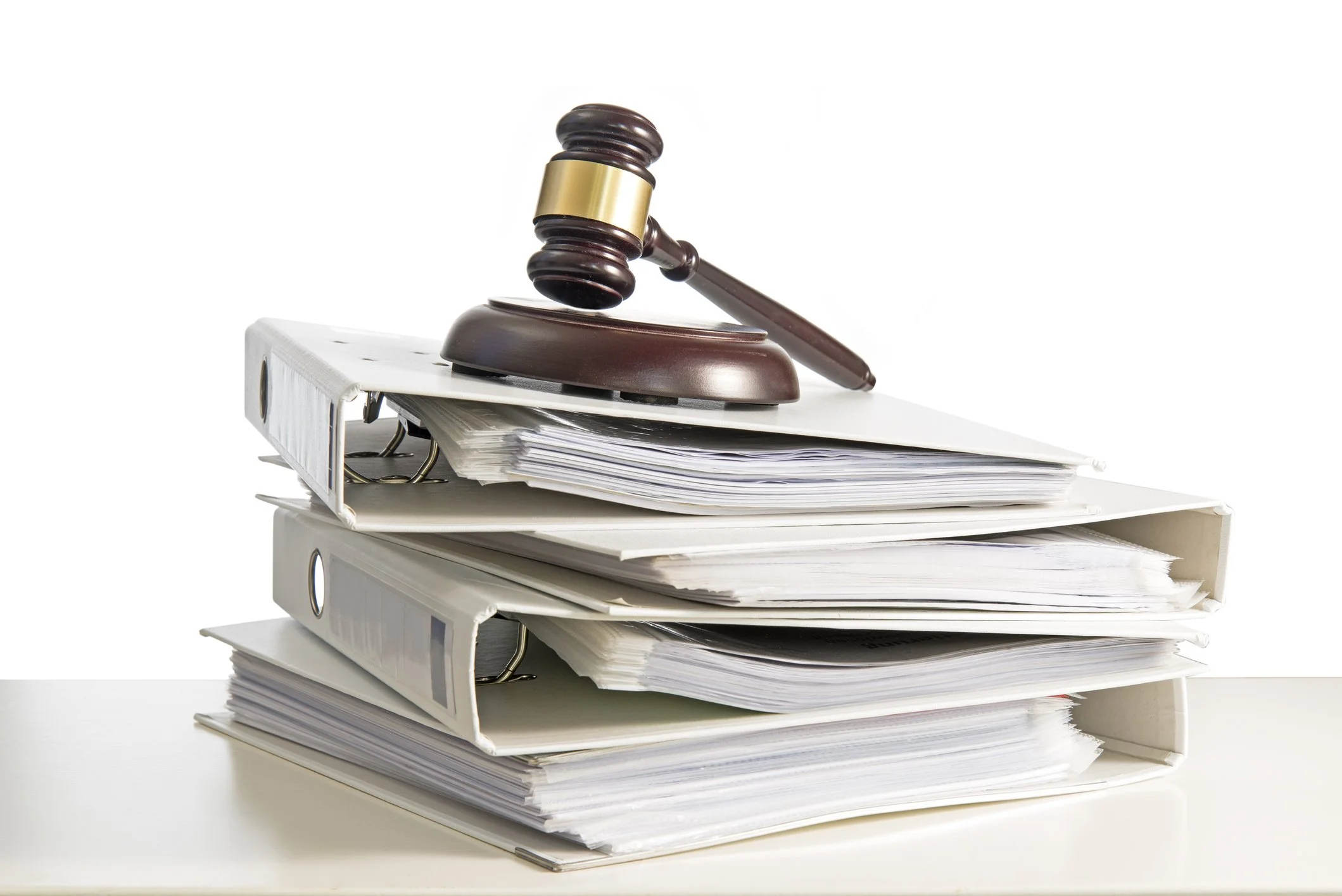 Gavel resting on a stack of large legal binders filled with papers.