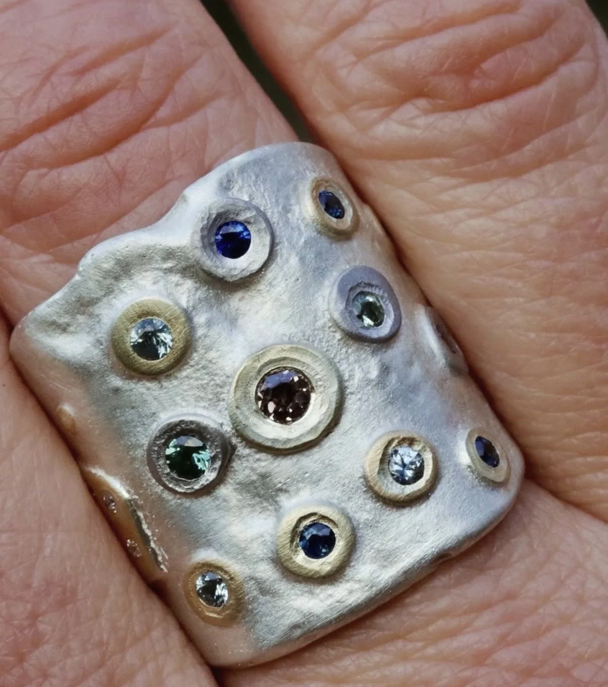 Ali Lee's elongated ring  with embedded multicolored gemstones.