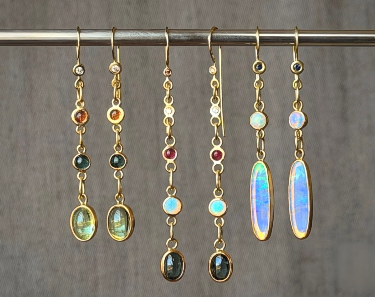 Carrie Armstrong's Ggold earrings with gemstones and opals.