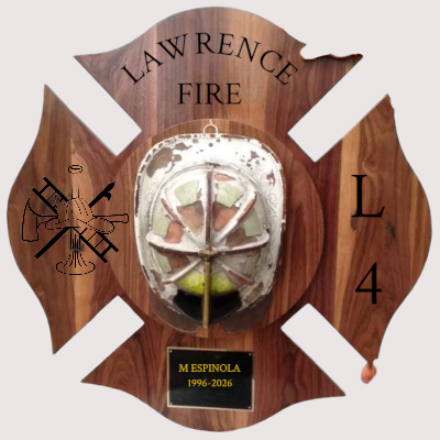 A wooden plaque shaped like a firefighter's Maltese cross,  with engraved text 'Lawrence Fire', a firefighter emblem, the number 4, and a plaque reading 'M Espinola 1996-2026'.