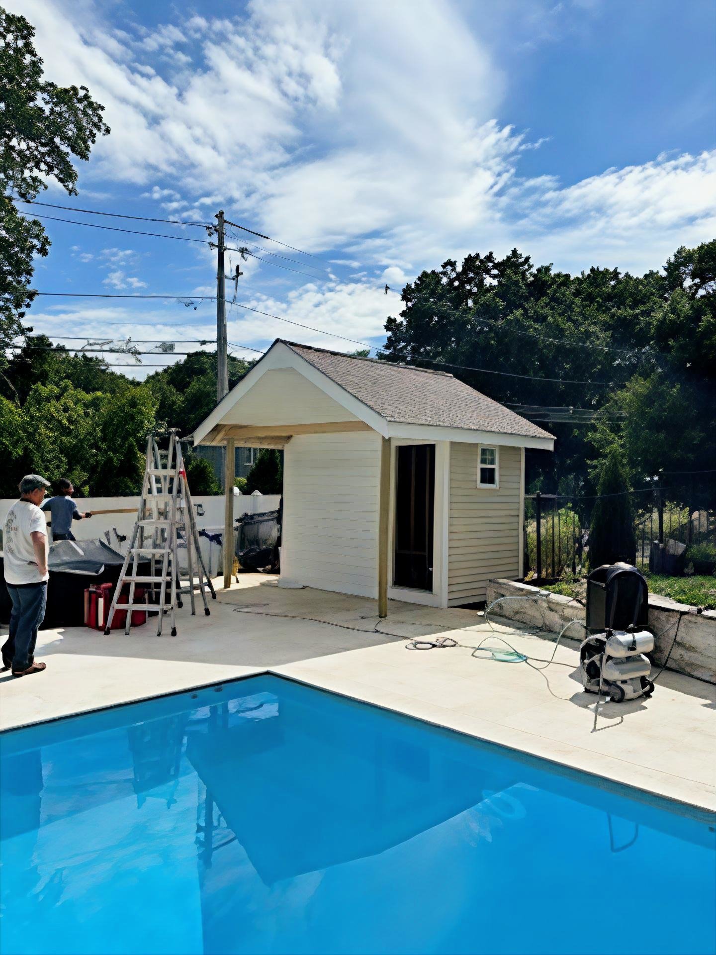 Backyard with a swimming pool, a small pool house under construction,