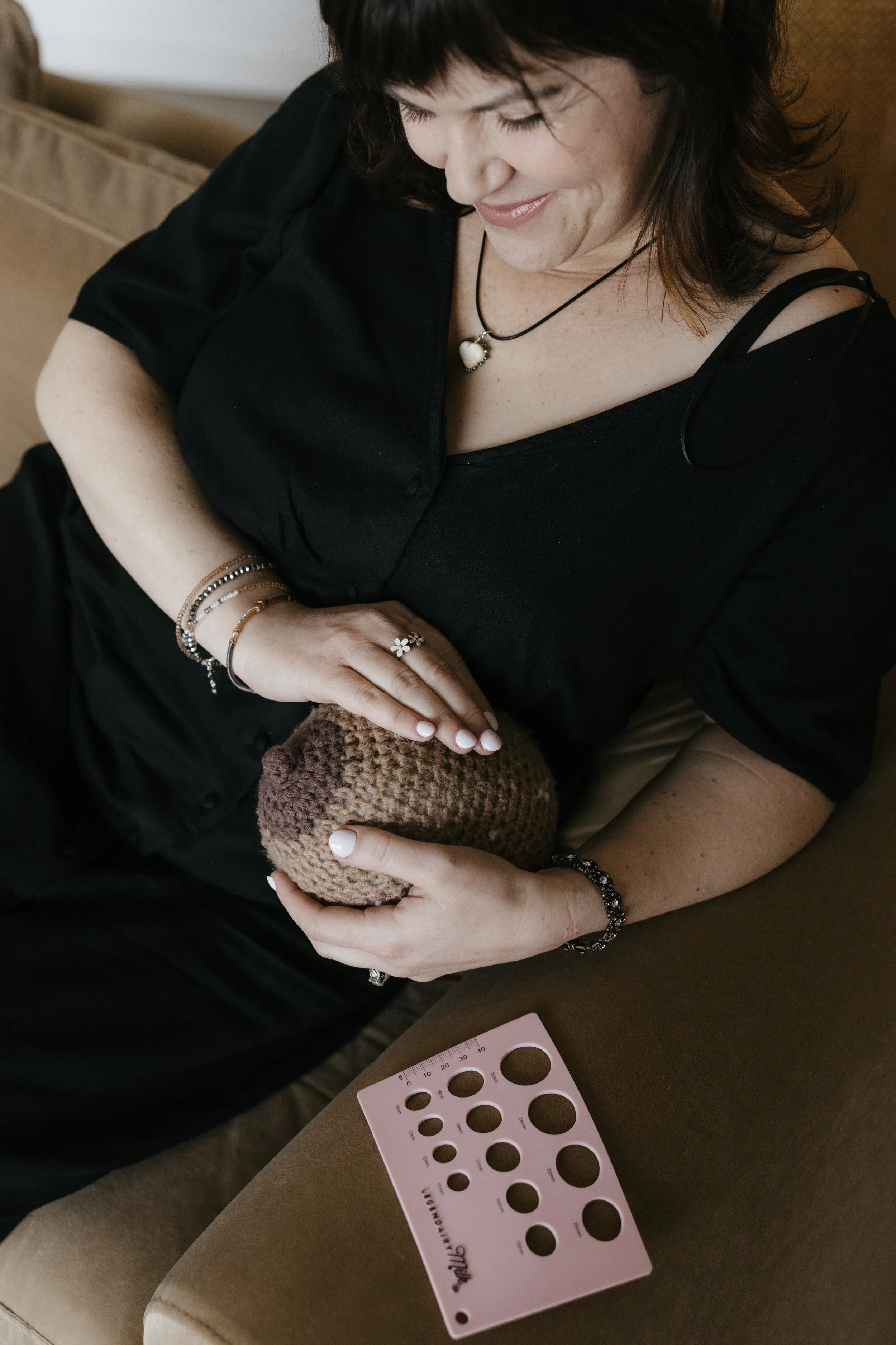 Lactation consultant holding a breast model with a nipple measurement tool below.