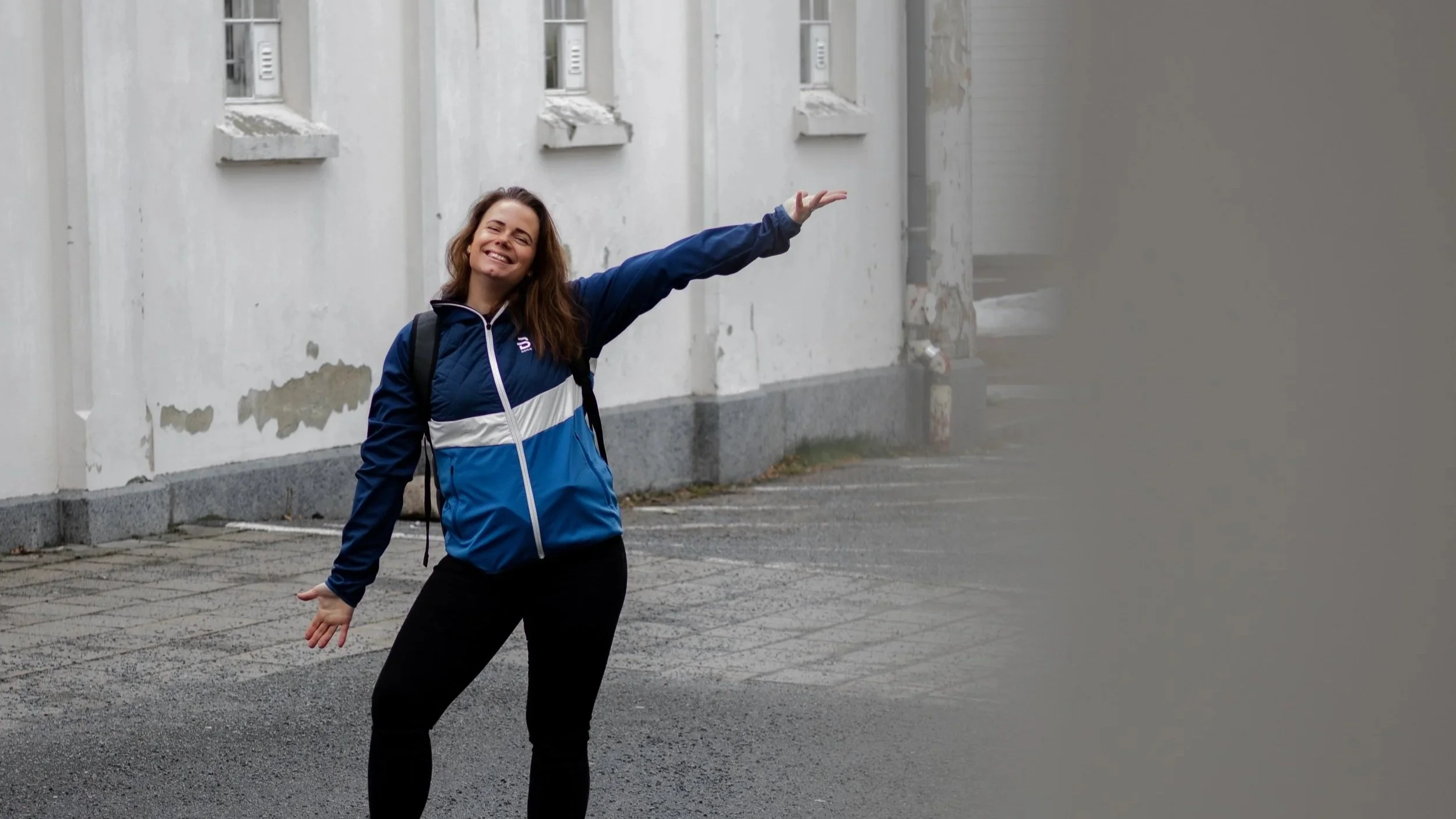 Kvinne med sekk smiler i bygate – frihet som gründer og livet med egen business.