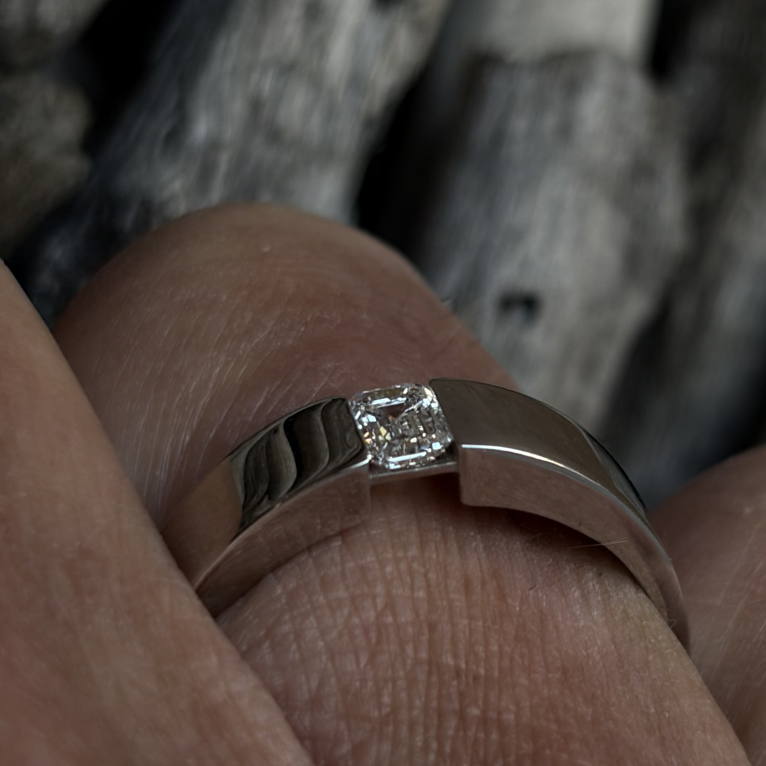 Close-up of ECHØ men’s engagement ring with natural colorless diamond held in tension