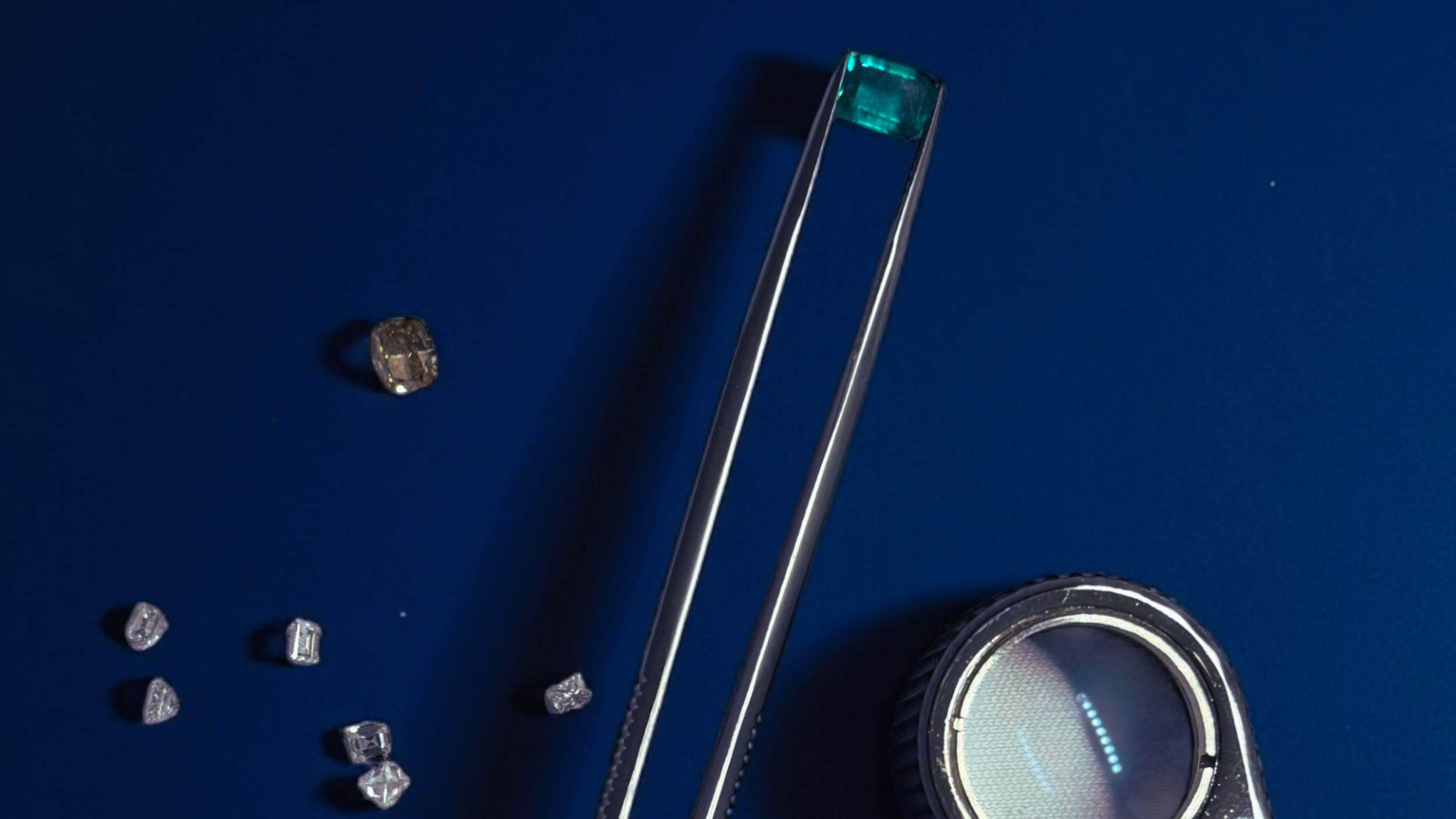 A digital scale with a blue background, small diamonds, a pair of tweezers, and a round digital display showing a few illuminated dots.