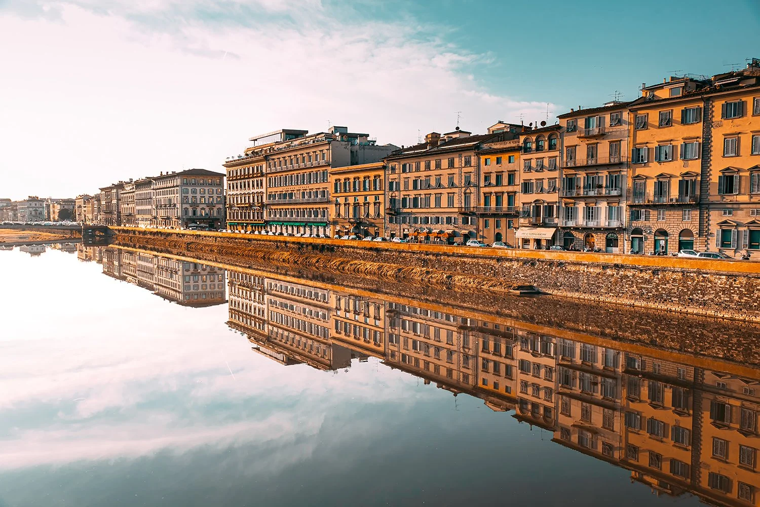 Golden reflections of Florence buildings in the river.