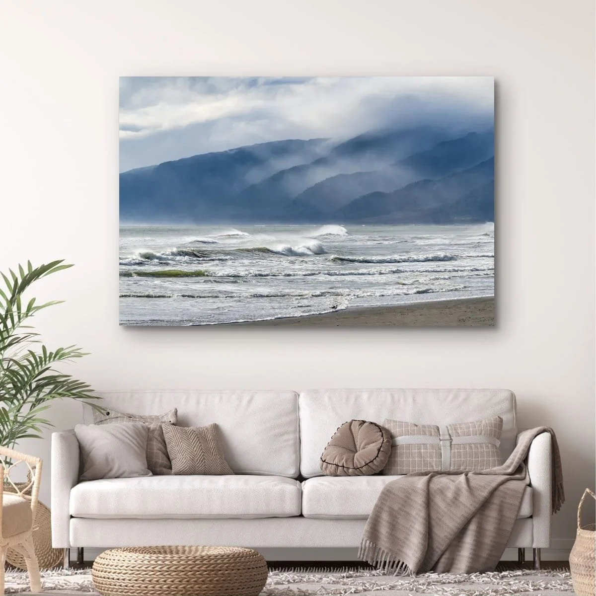 Waves breaking beneath mist-covered mountain ranges on the West Coast of New Zealand.