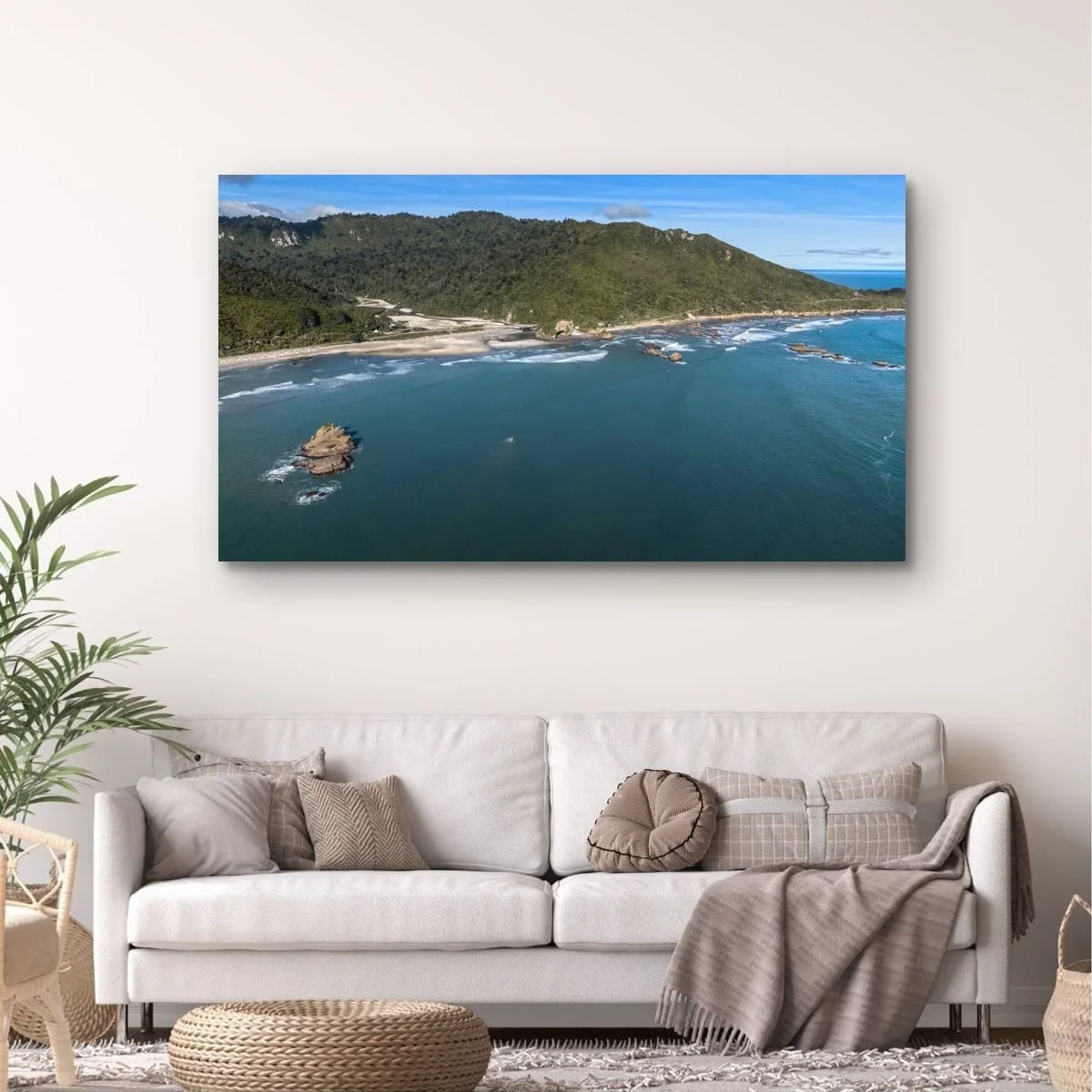 Aerial coastal landscape with offshore rock formation and rugged shoreline.