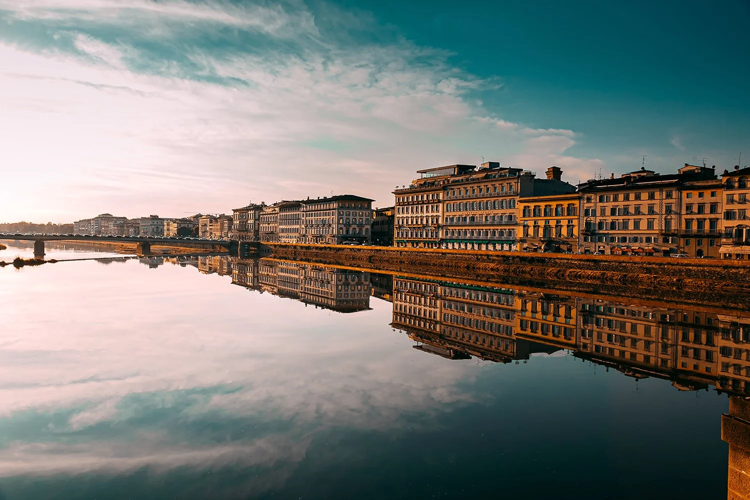 Golden reflections of Florence buildings in the river.