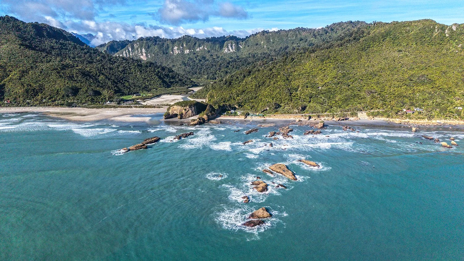 Aerial view of rocky coastline and ocean currents on New Zealand's West Coast.