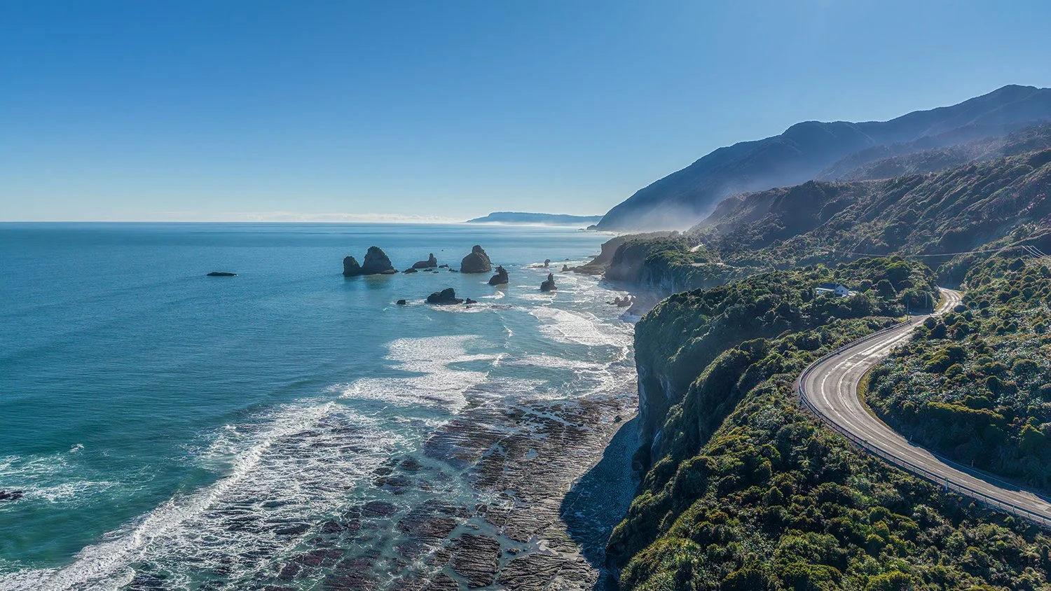 West Coast aerial view where mountains meet the Tasman Sea.