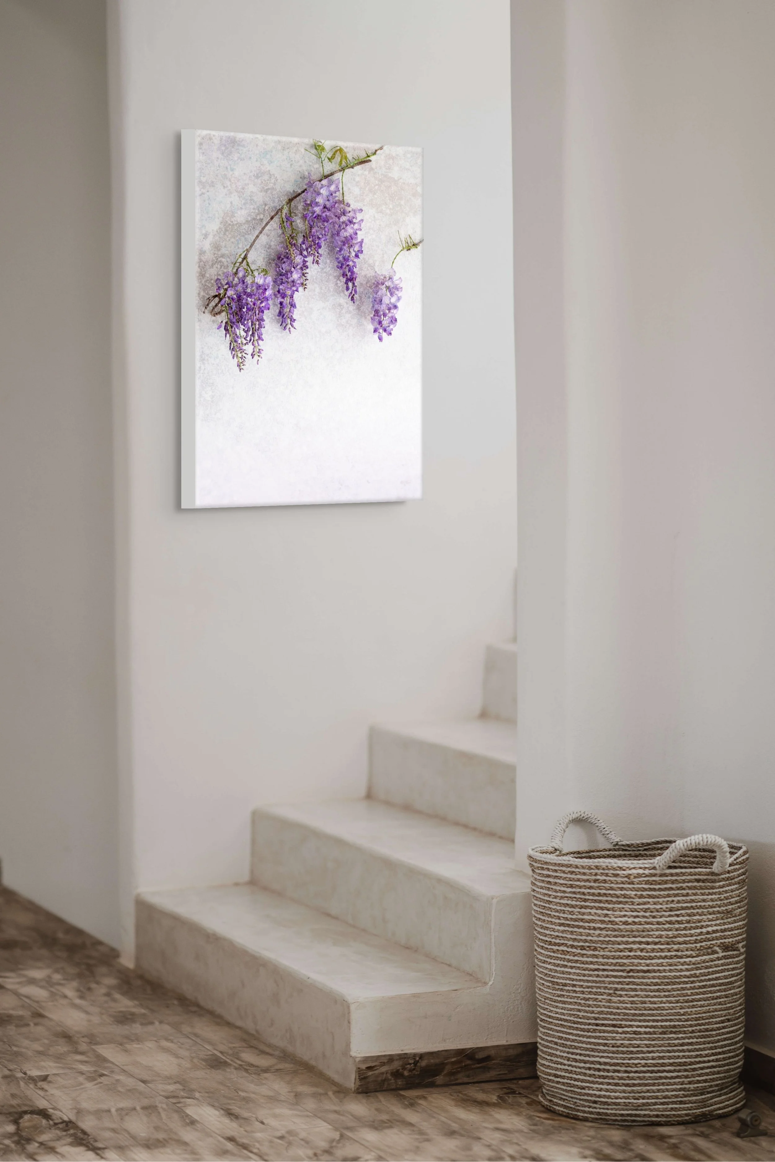 Purple wisteria flowers cascading from a branch against a soft textured background.