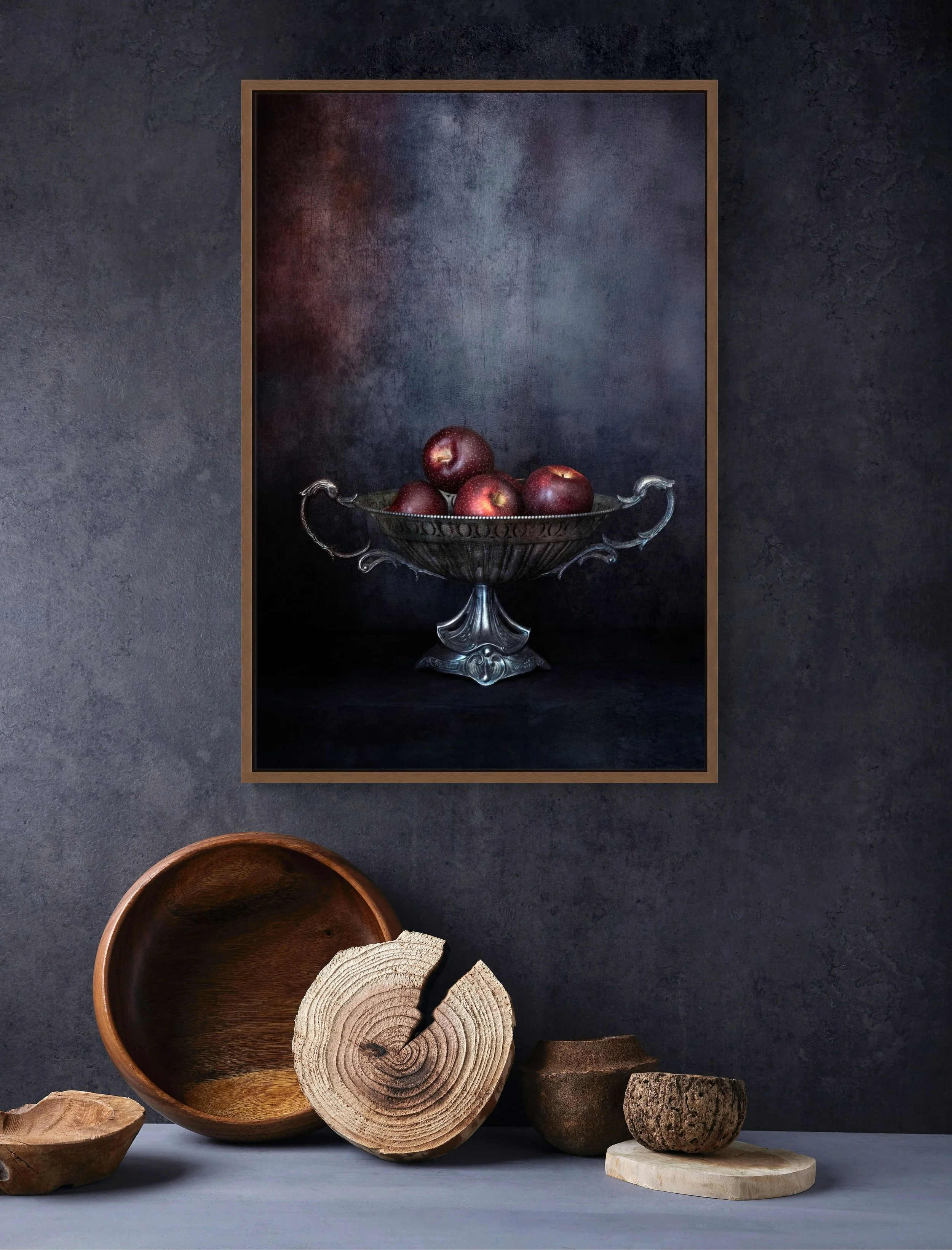 Red apples in vintage silver bowl in moody still life photography.