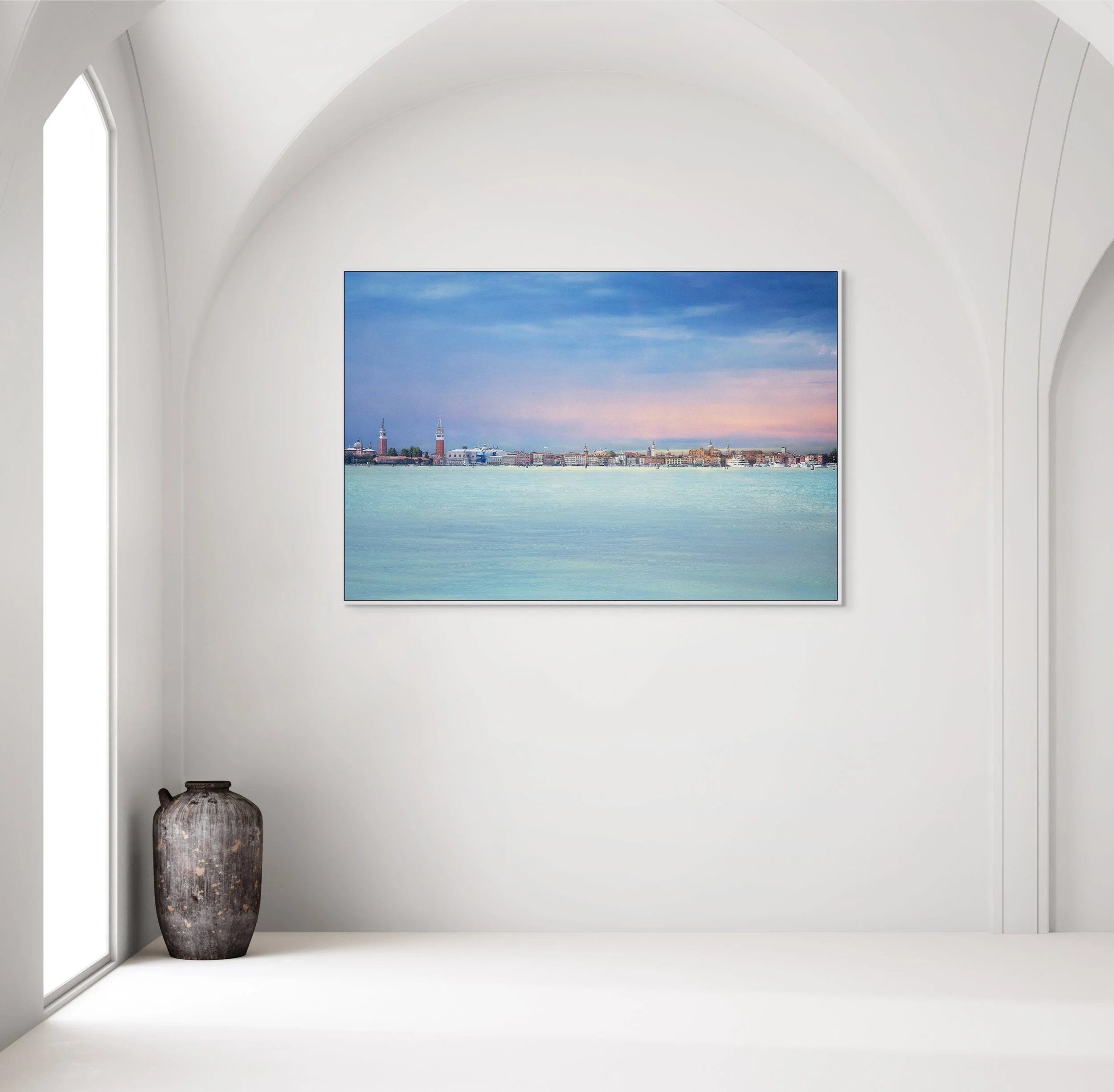 Panoramic view of Venice skyline across the lagoon under a pastel sky.