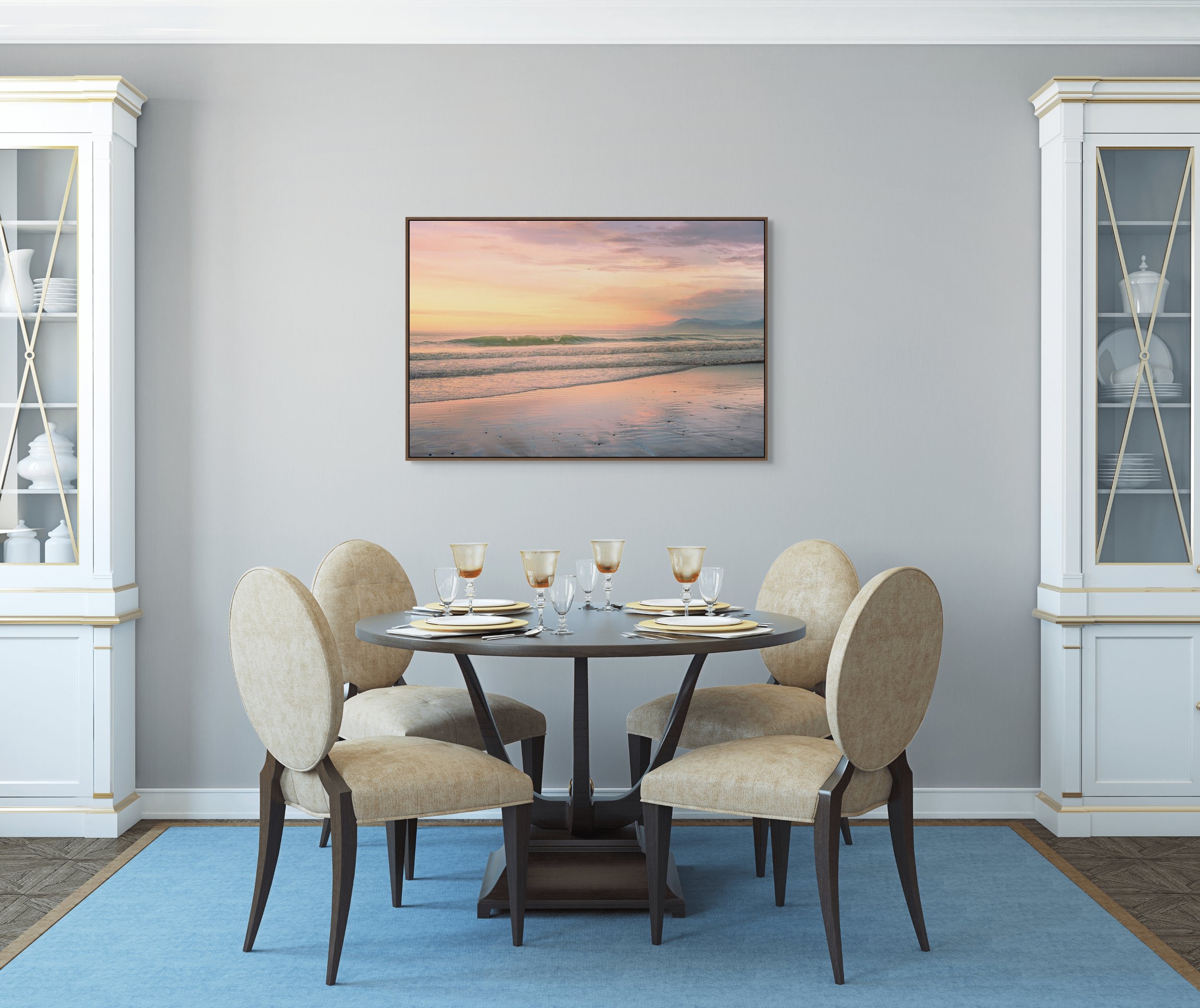 Soft ocean waves at sunrise with pastel sky and distant mountains.