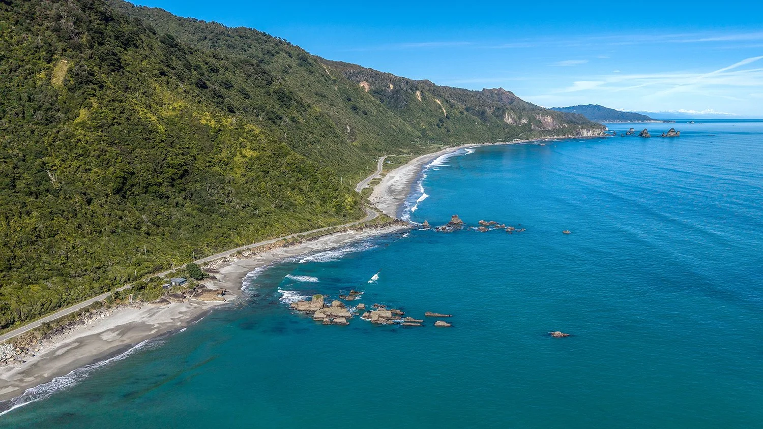 Aerial coastline showing the Great Coast Road and ocean.