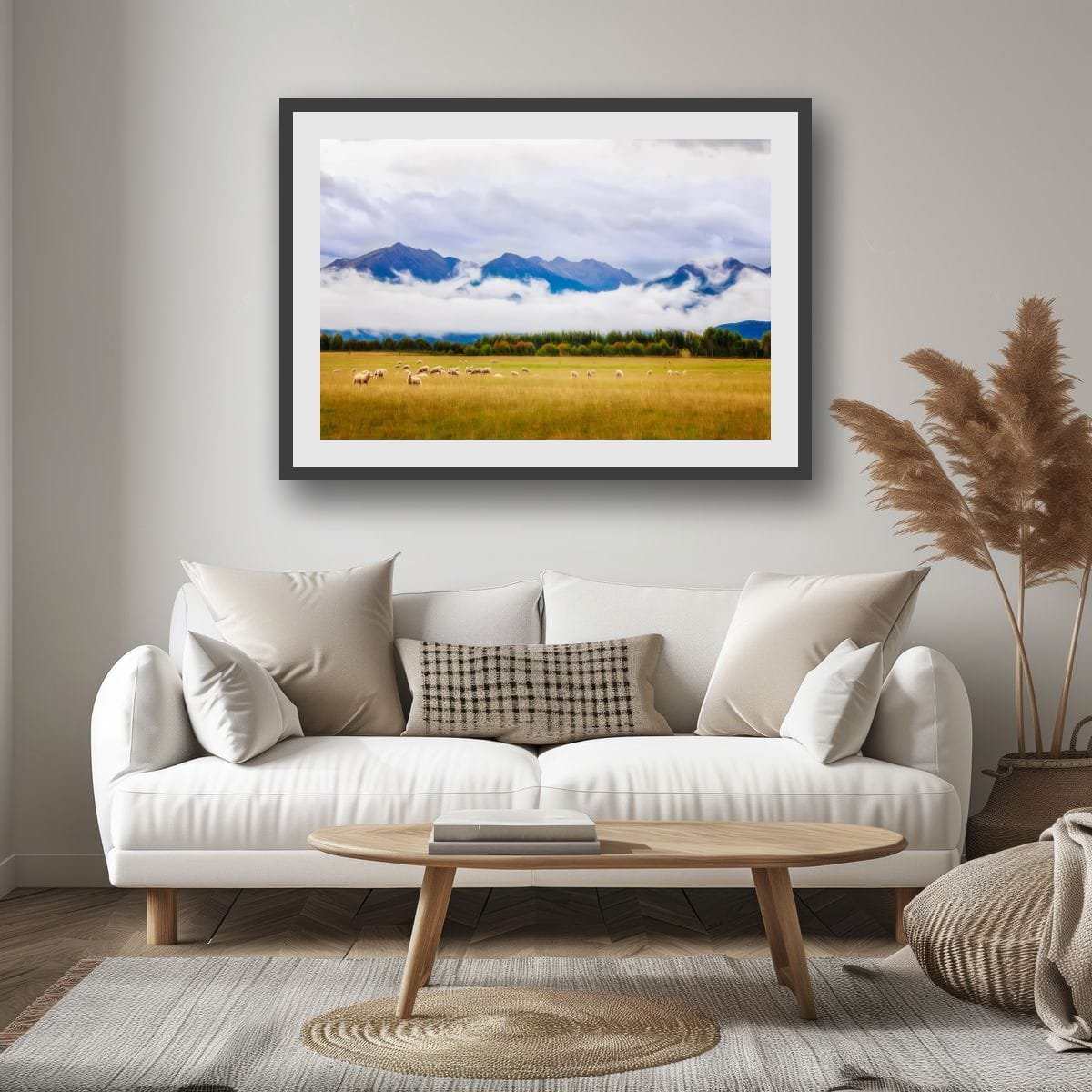 Sheep grazing in a field beneath mountains and low cloud.