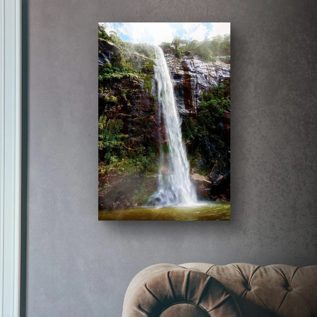 Waterfall flowing down a cliff face in Milford Sound surrounded by rainforest.
