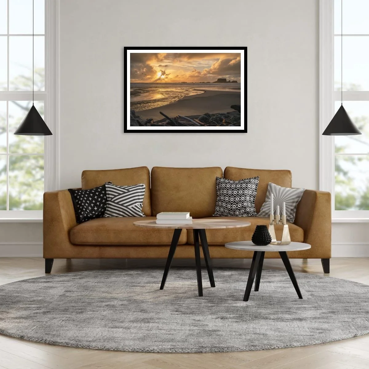 Golden sunlight breaking through clouds over a beach, tidal stream, seabirds and distant rocky sea stacks.