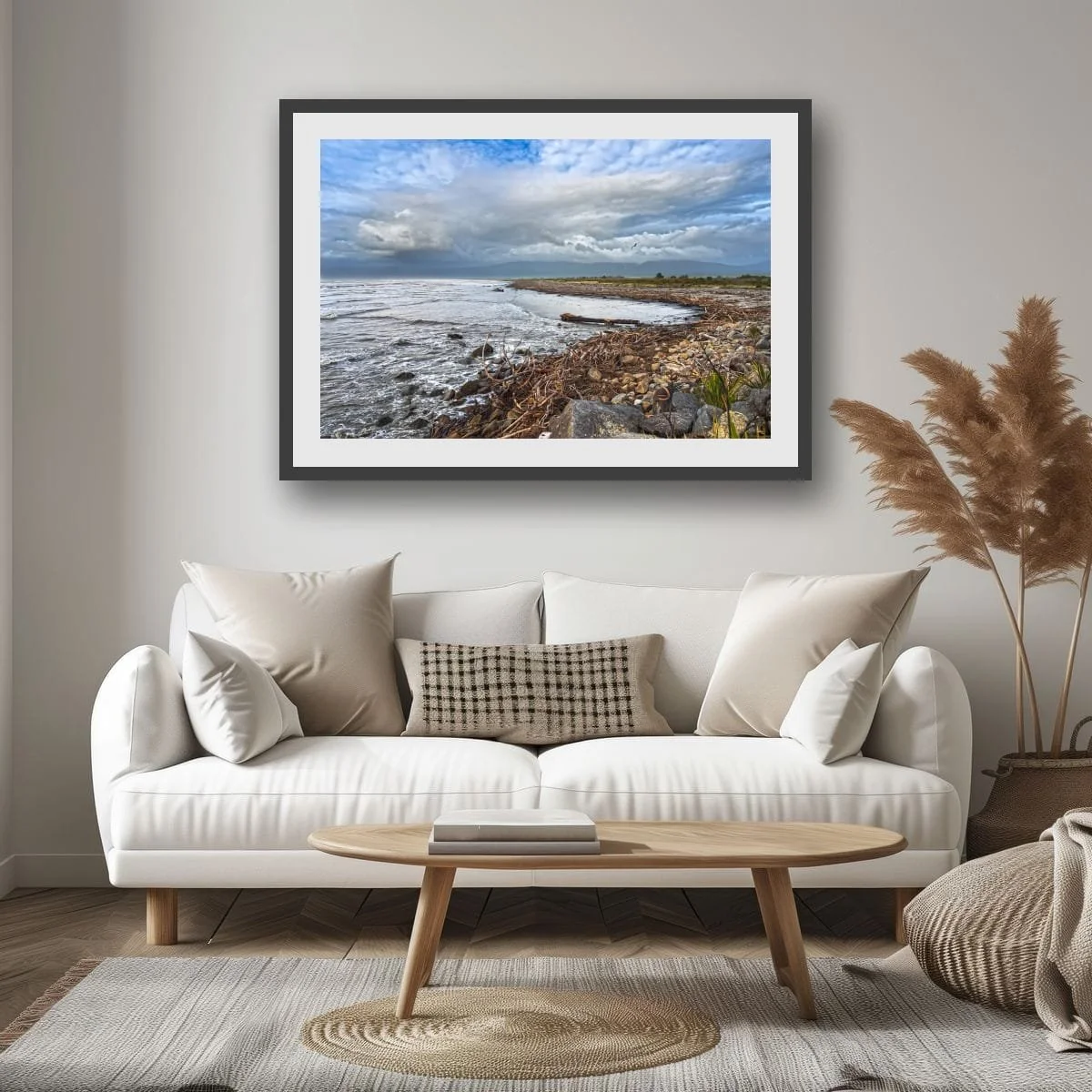 Fine art coastal photograph featuring driftwood, rocky shoreline and dramatic clouds along the New Zealand West Coast.