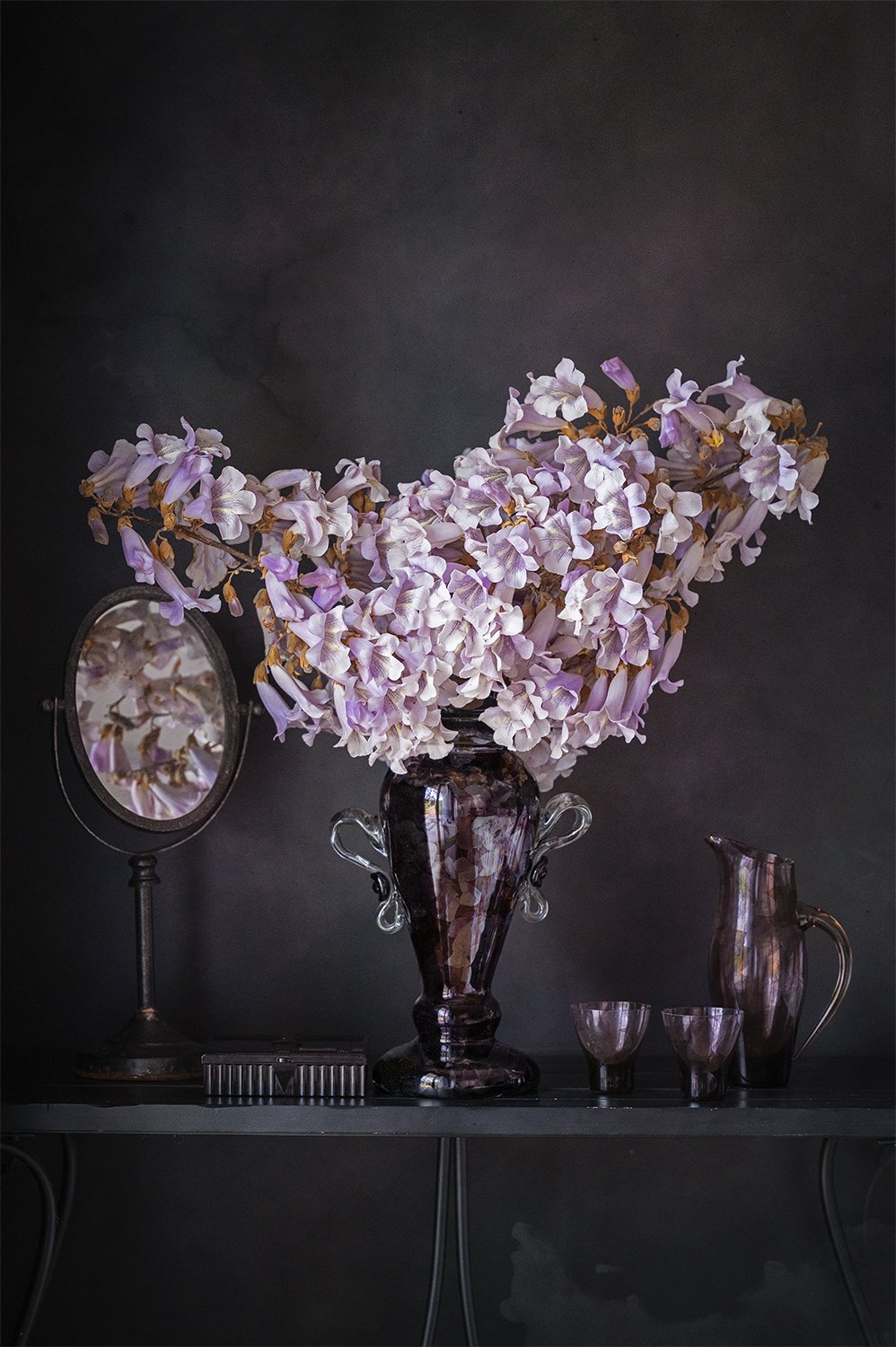 Pale pink flowers arranged in vintage glass vessels.