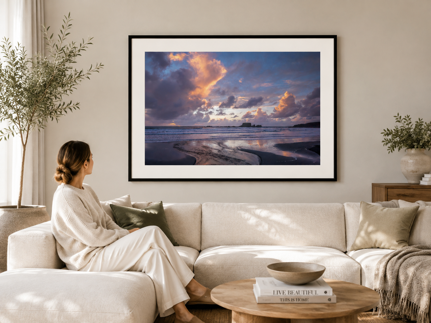 Pastel pink and violet dusk clouds reflected on a West Coast beach with ocean waves and dark sea stacks.