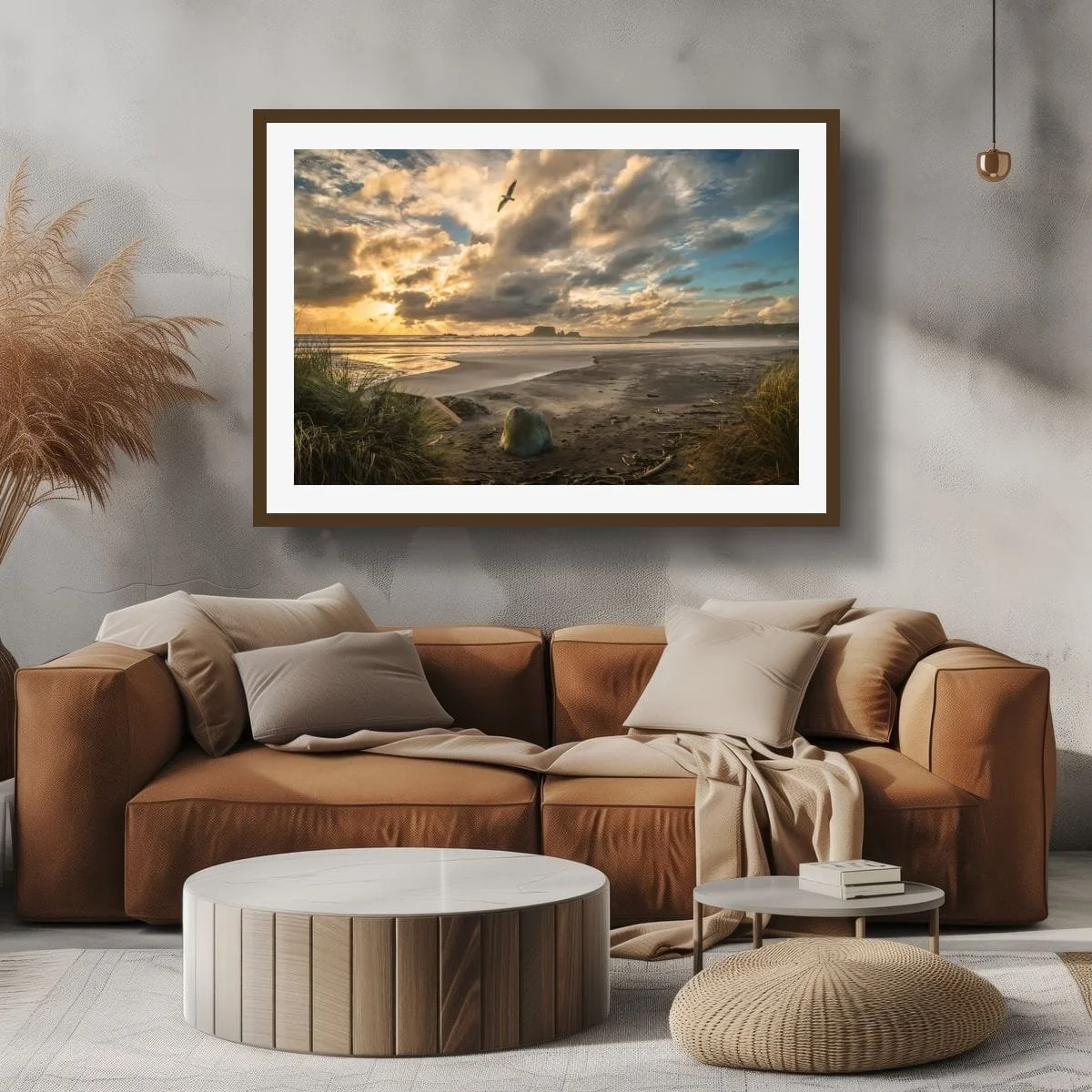 Seabird gliding over a golden coastal sunset with beach grasses, wet sand, ocean and offshore rock formations.