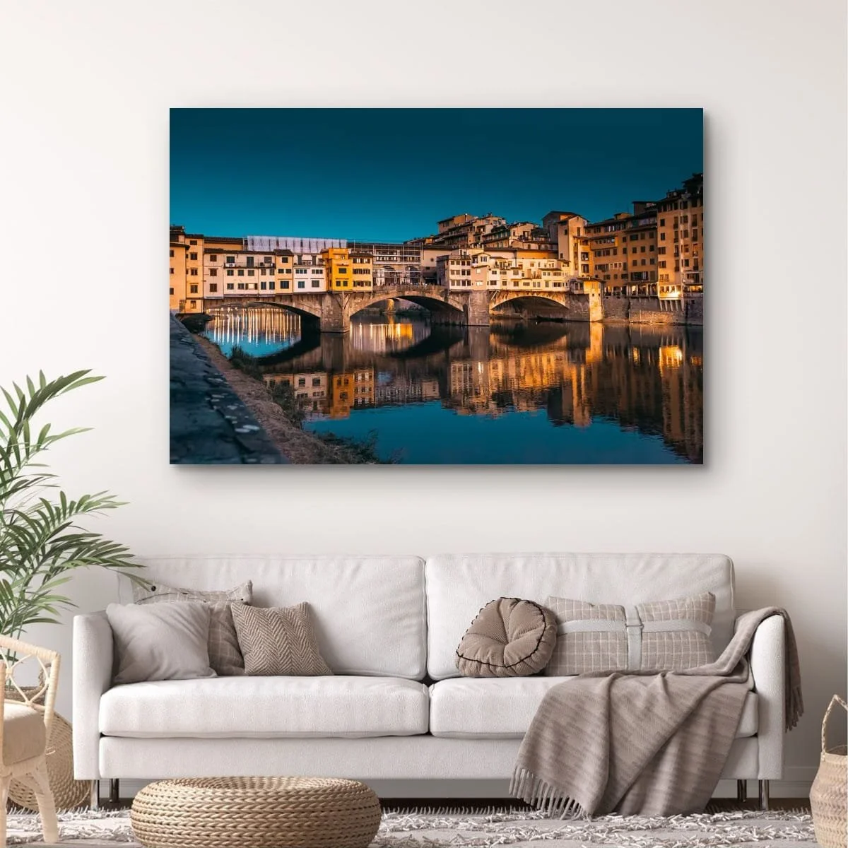 Ponte Vecchio bridge illuminated at dusk with reflections in the Arno River.