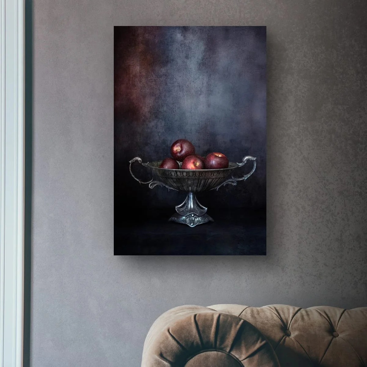 Red apples displayed in an ornate silver bowl against a dark background.
