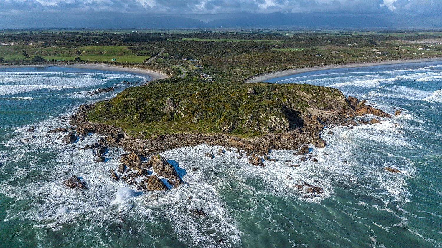 Aerial view of Cape Foulwind surrounded by ocean.