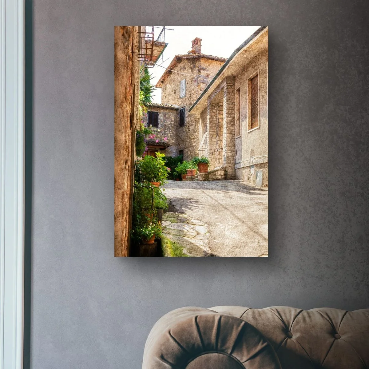 Narrow Tuscan laneway lined with flowers, stone walls and historic buildings.