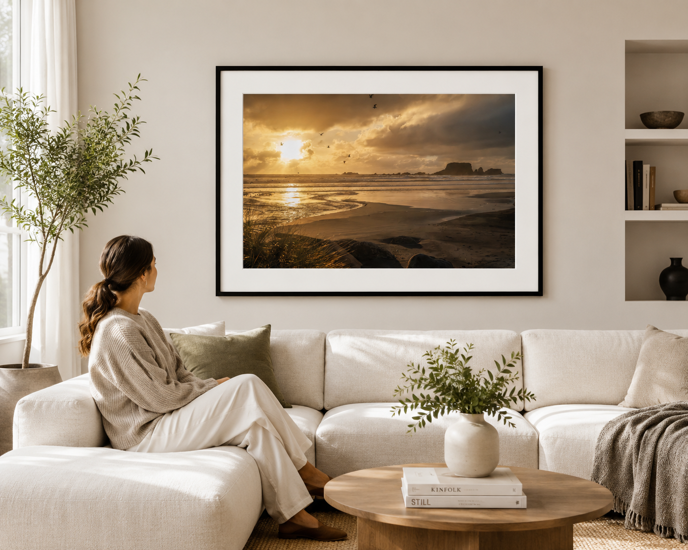Seabirds flying across a golden sunset above wet sand, ocean waves and distant coastal rock formations.