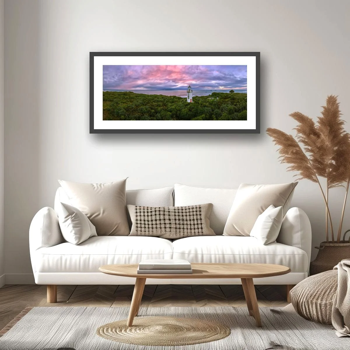 Panoramic view of a historic lighthouse surrounded by native bush at sunset.