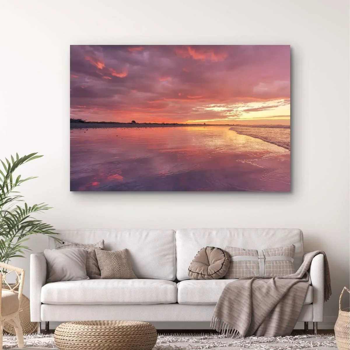 Pink sunset reflected across wet beach sand.