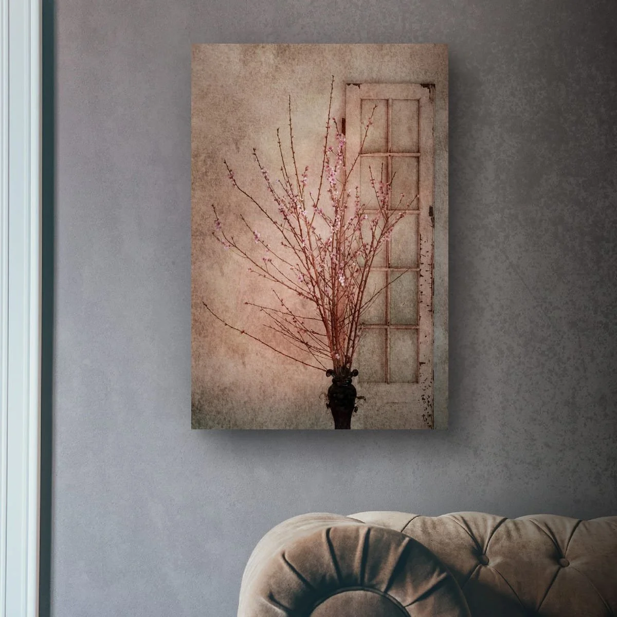 Pink blossom arrangement beside a vintage window.