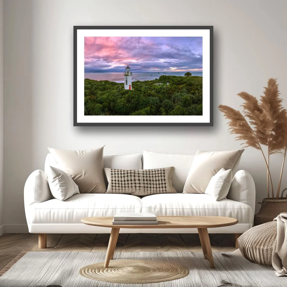 Panoramic view of a historic lighthouse surrounded by native bush at sunset.